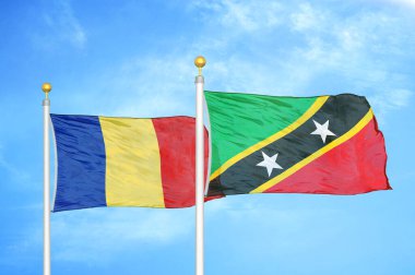 Romanya ve Saint Kitts ve Nevis bayrak direkleri ve mavi bulutlu arka planda iki bayrak