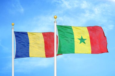 Romanya ve Senegal bayrak direkleri ve mavi bulutlu arka plan üzerinde iki bayrak