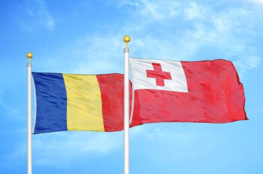 Romanya ve Tonga bayrak direkleri ve mavi bulutlu arka planda iki bayrak