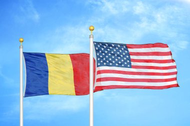 Romanya ve ABD bayrak direkleri ve mavi bulutlu arka planda iki bayrak