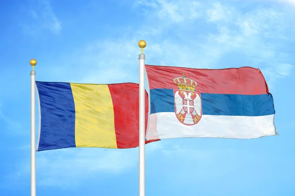 Roemenië Servië Twee Vlaggen Vlaggenmasten Blauwe Bewolkte Lucht Achtergrond — Stockfoto