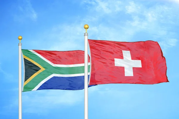 南アフリカとスイスの旗竿と青空の背景に2つの旗 — ストック写真