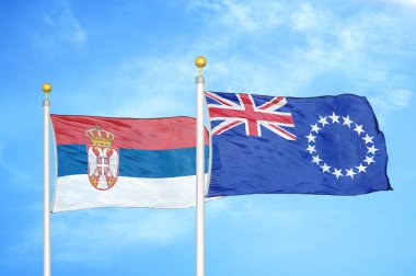 Sırbistan ve Cook Adaları bayrak direkleri ve mavi bulutlu arka planda iki bayrak