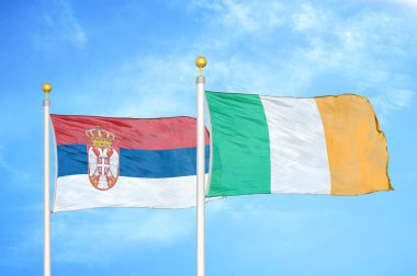 Sırbistan ve İrlanda bayrak direkleri ve mavi bulutlu arka planda iki bayrak