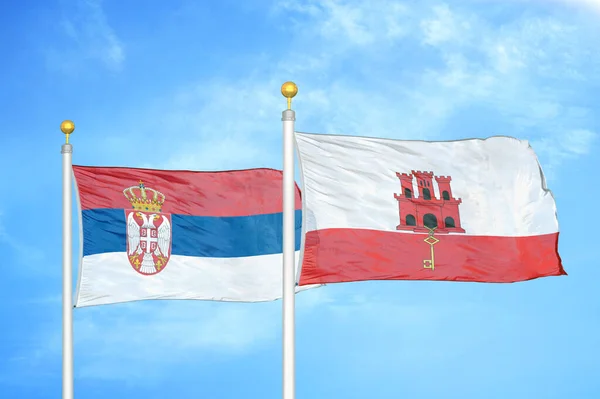 Serbia Gibraltar Dwie Flagi Maszcie Flagowym Niebieskie Zachmurzone Tło Nieba — Zdjęcie stockowe
