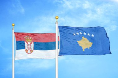 Sırbistan ve Kosova bayrak direkleri ve mavi bulutlu arka planda iki bayrak