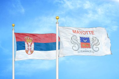Sırbistan ve Mayotte bayrak direkleri ve mavi bulutlu arka planda iki bayrak