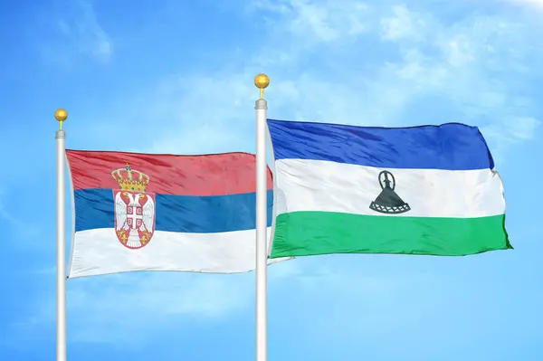 Servië Lesoth Twee Vlaggen Vlaggenmasten Blauwe Bewolkte Lucht Achtergrond — Stockfoto