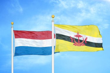 Hollanda ve Brunei bayrak direkleri ve mavi bulutlu arka planda iki bayrak