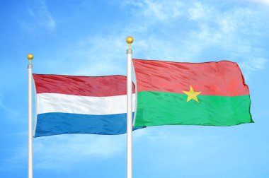 Hollanda ve Burkina Faso bayrak direkleri ve mavi bulutlu arka planda iki bayrak