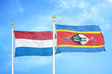 Hollanda ve Eswatini Svaziland bayrak direkleri ve mavi bulutlu arka planda iki bayrak