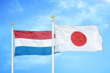 Hollanda ve Japonya bayrak direkleri ve mavi bulutlu arka planda iki bayrak