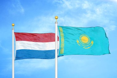 Hollanda ve Kazakistan bayrak direkleri ve mavi bulutlu arka planda iki bayrak