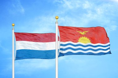 Hollanda ve Kiribati bayrak direkleri ve mavi bulutlu arka planda iki bayrak