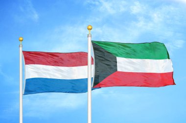 Hollanda ve Kuveyt bayrak direkleri ve mavi bulutlu arka planda iki bayrak