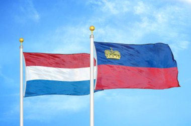 Hollanda ve Lihtenştayn bayrak direkleri ve mavi bulutlu arka planda iki bayrak
