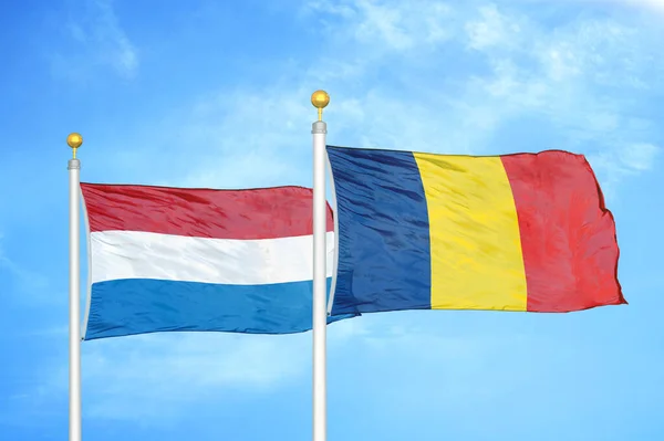 Nederland Tsjaad Twee Vlaggen Vlaggenmasten Blauwe Bewolkte Hemelachtergrond — Stockfoto