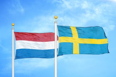 Hollanda ve İsveç bayrak direkleri ve mavi bulutlu arka planda iki bayrak