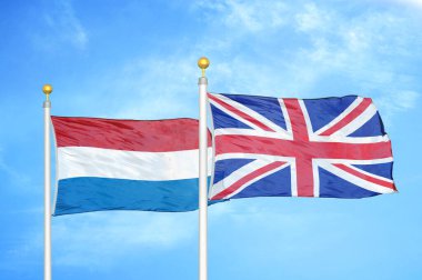 Hollanda ve Birleşik Krallık bayrak direkleri ve mavi bulutlu arka planda iki bayrak