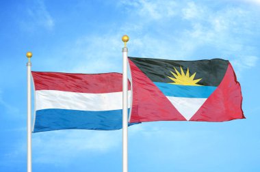 Hollanda, Antigua ve Barbuda bayrak direkleri üzerinde iki bayrak ve mavi bulutlu gökyüzü arkaplanı