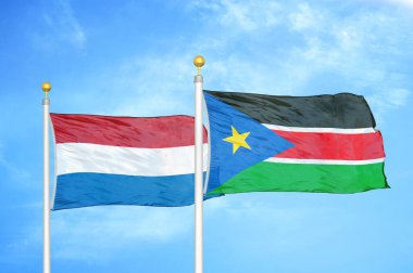 Hollanda ve Güney Sudan bayrak direkleri ve mavi bulutlu arka planda iki bayrak