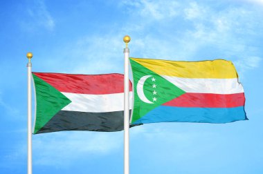 Sudan ve Comoros bayrak direkleri üzerinde iki bayrak ve mavi bulutlu arka plan