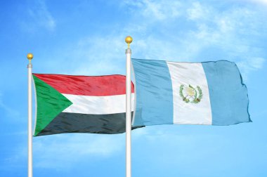 Sudan ve Guatemala bayrak direkleri ve mavi bulutlu arka planda iki bayrak