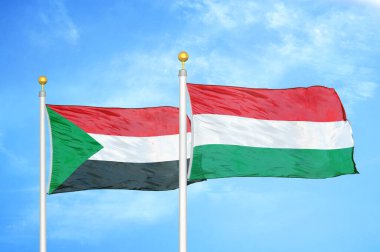Sudan ve Macaristan bayrak direkleri ve mavi bulutlu arka planda iki bayrak