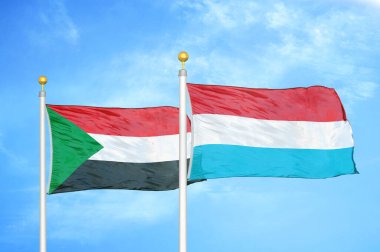 Sudan ve Lüksemburg bayrak direkleri üzerinde iki bayrak ve mavi bulutlu arka plan
