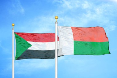 Sudan ve Madagaskar bayrak direkleri üzerinde iki bayrak ve mavi bulutlu arka plan
