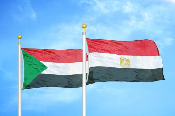 Sudão Egito Duas Bandeiras Postes Bandeira Azul Céu Nublado Fundo — Fotografia de Stock
