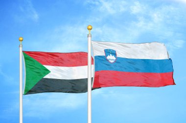 Sudan ve Slovenya bayrak direkleri ve mavi bulutlu arka planda iki bayrak