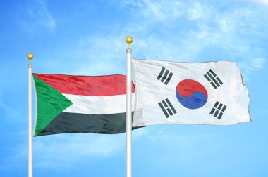 Sudan ve Güney Kore bayrak direkleri ve mavi bulutlu arka planda iki bayrak