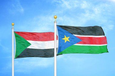Sudan ve Güney Sudan bayrak direkleri üzerinde iki bayrak ve mavi bulutlu arka plan
