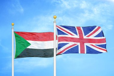 Sudan ve Birleşik Krallık bayrak direkleri üzerinde iki bayrak ve mavi bulutlu arka plan