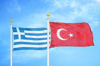 Yunanistan ve Türkiye bayrak direkleri ve mavi bulutlu arka planda iki bayrak