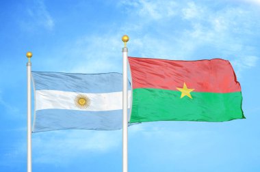 Arjantin ve Burkina Faso bayrak direkleri ve mavi bulutlu arka planda iki bayrak