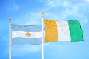 Arjantin ve Fildişi Fildişi Sahilleri bayrak direkleri ve mavi bulutlu arka planda iki bayrak