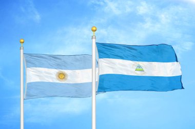 Arjantin ve Nikaragua bayrak direkleri ve mavi bulutlu arka planda iki bayrak