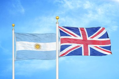 Arjantin ve Birleşik Krallık bayrak direkleri üzerinde iki bayrak ve mavi bulutlu arka plan