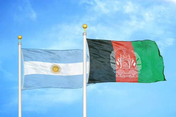Argentina and Afghanistan two flags on flagpoles and blue cloudy sky background