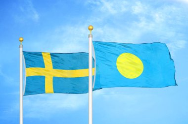 İsveç ve Palau bayrak direkleri ve mavi bulutlu arka planda iki bayrak