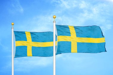 İsveç bayrak direğinde iki bayrak ve mavi bulutlu gökyüzü arkaplanı