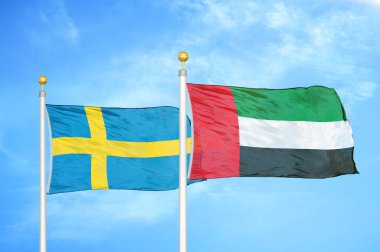 İsveç ve Birleşik Arap Emirlikleri bayrak direkleri ve mavi bulutlu arka planda iki bayrak