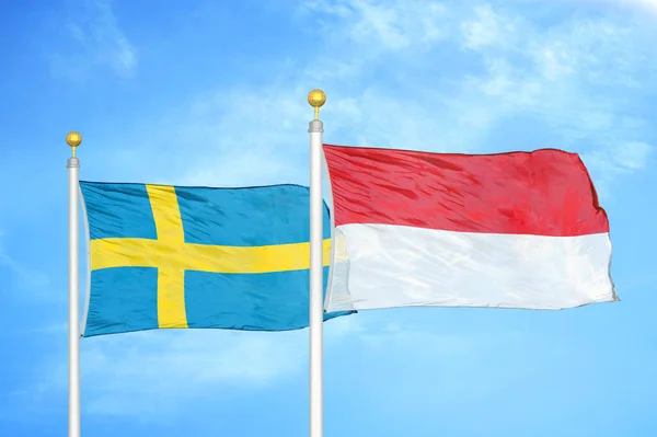 スウェーデンとインドネシアの旗竿と青空の背景に2つの旗 — ストック写真