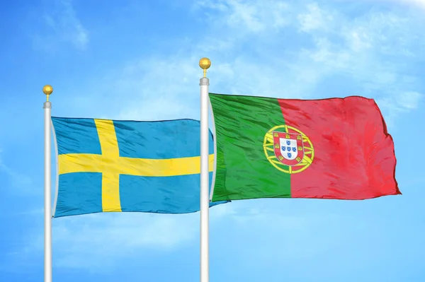 Sweden and Portugal two flags on flagpoles and blue cloudy sky background