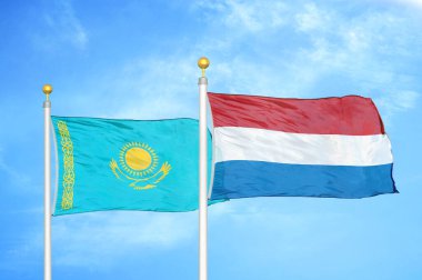 Kazakistan ve Hollanda bayrak direkleri ve mavi bulutlu arka planda iki bayrak