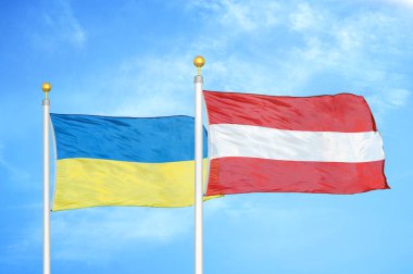 Ukrayna ve Avusturya bayrak direkleri ve mavi bulutlu arka planda iki bayrak