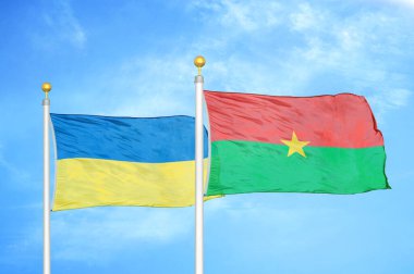Ukrayna ve Burkina Faso bayrak direkleri ve mavi bulutlu arka planda iki bayrak