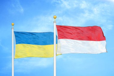 Ukrayna ve Endonezya bayrak direkleri üzerinde iki bayrak ve mavi bulutlu arka plan